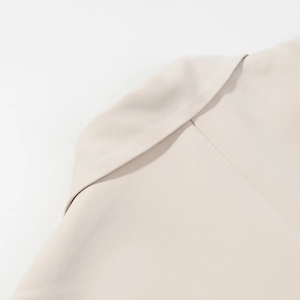Detail of the sharp shoulder tailoring and lapel collar on this beige office suit set