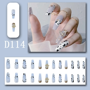 Detail view of model hands and 24pcs long coffin press on nails with bow and cow print