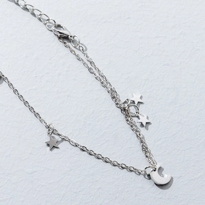 Detail of silver star and moon charms on double layer chain bracelet with ethnic style