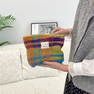 Close-up of colorful checkered plush makeup bag with sozakka beauté label in hand