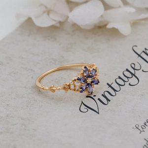 Detailed close-up of a vintage 14K gold ring with purple tanzanite-like floral gems