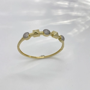 Golden fashion bangle with pavé-set round crystals and pyramid geometric charms