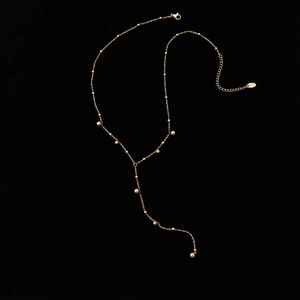 Long gold tassel Y-necklace with metallic beads on minimalist stainless steel chain