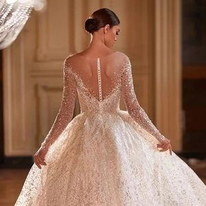 Close-up of luxury wedding dress featuring sheer tulle back and delicate button closure