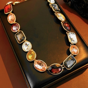 Dettaglio macro della collana vintage dorata con pietre preziose tonde e rettangolari