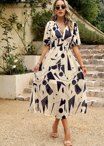 Détail de robe à col en V et manches bouffantes avec motif géométrique noir et blanc sur beige