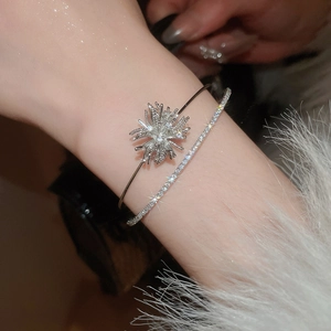 Detailed view of layered silver-tone bangles with starburst design and pavé cubic zirconia