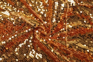 Gros plan de paillettes dorées haute densité sur tissu mesh avec reflets métalliques brillants