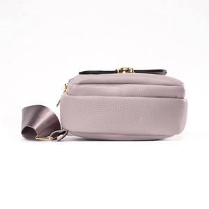 Purple pebbled leather sling bag with rivet design and wide nylon strap shown from side