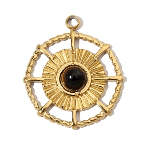 Detailed macro view of a gold solar-shaped pendant with a dark brown round gemstone