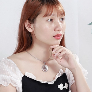 Minimalist silver stainless steel round pendant with engraved totem on a female model
