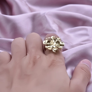 Anello a fiore in acciaio inossidabile dorato 18K su sfondo di seta viola
