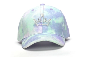 Close-up of tie-dye baseball cap featuring a sparkling rhinestone crown on the front