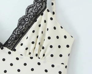Detalle del vestido crema con lunares y elegante encaje negro en el escote en forma de V