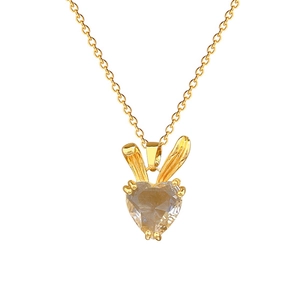 Luxurious gold rabbit ear necklace with heart-shaped crystal pendant on white background