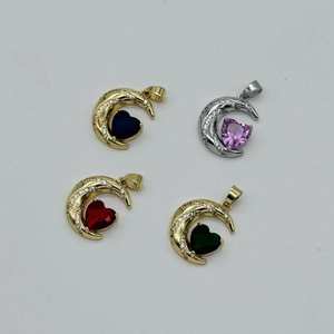 Macro shot of heart-shaped crystal charms in gold and silver moon frames with zircons