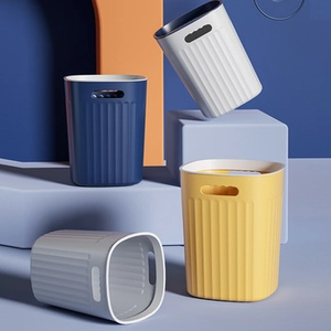 Detailed view of four colorful oval plastic waste bins with vertical ribbed design and handles