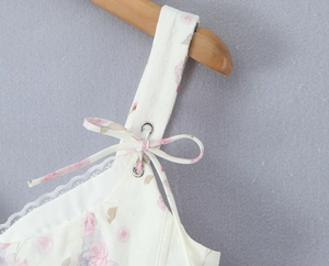 Macro shot of floral mesh lace trim and adjustable bow shoulder straps with metal eyelets