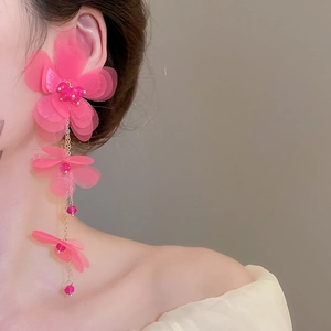 Close-up of pink chiffon flower tassel earrings with delicate beaded center and gold chain