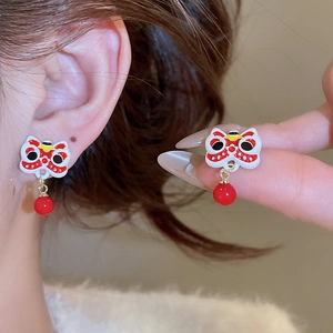 Détail de boucles d'oreilles danse du lion chinois avec pompons de perles rouges et émail