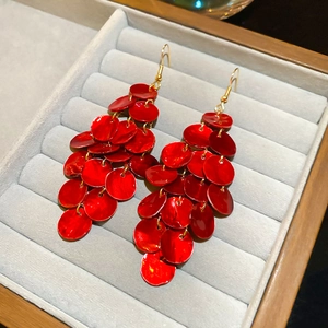 Detail von roten gestuften Scheiben-Ohrringen mit Goldhaken auf grauem Samt-Tablett