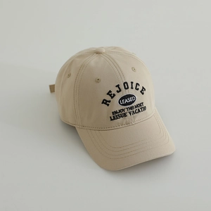 Close-up of beige cotton baseball cap featuring black embroidered letters and 6-panel design