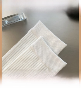 Detailed close-up of high-elastic ribbed cuffs on white combed cotton mid-calf socks
