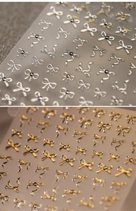 Vue macro détaillée de stickers 5D pour ongles, papillons argentés et dorés à texture métallique