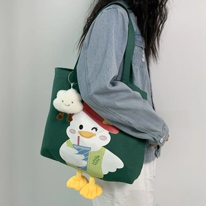 Close-up of deep green canvas tote bag with cute cartoon duck print and cloud charm