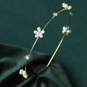 Dettaglio del cerchietto dorato con fiori di perle bianche e cristalli lucenti