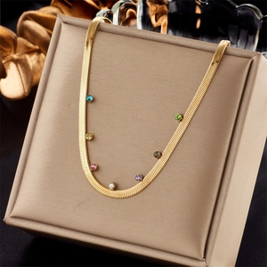 Detail of golden snake chain necklace with vibrant multi-colored inlaid gemstones