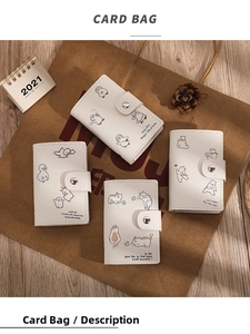 Detailed view of four cute cartoon animal illustration card holders on a rustic desk