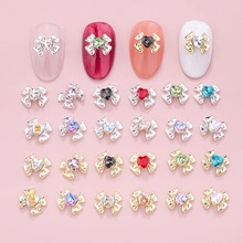 Detailed macro view of 3D alloy bow nail charms with colorful heart-shaped rhinestones
