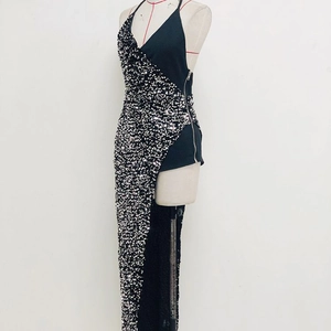 Detail of sequined asymmetric evening gown with halter neck and side zipper closure