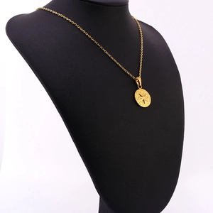 Detail of 18K gold stainless steel coin pendant with starburst and hammered texture