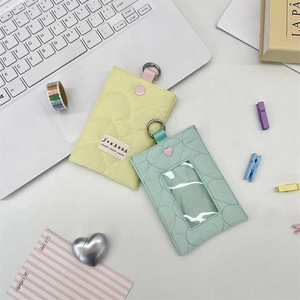 Detailed view of quilted heart card holders in yellow and mint green with metal rings