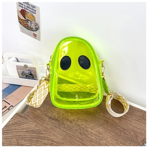 Detail of neon green transparent PVC crossbody bag with alien eye design and geometric strap
