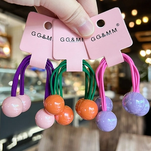 Close-up of vibrant elastic hair ties with colorful double spheres in pink, orange and purple