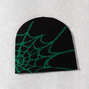 Detail view of black knitted beanie featuring a vibrant green spider web jacquard pattern