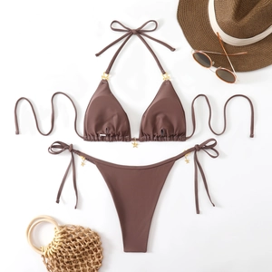 Detail of mocha bikini featuring golden star charms and halter neck on beach accessories