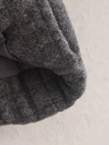 Gros plan sur la texture en laine gris foncé et les coutures d'un blouson aviateur