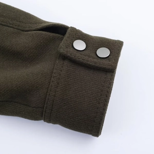 Detailed close-up of dark olive wool jacket cuffs with matte silver metal snap buttons