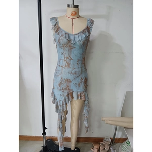 Detail of irregular ruffled hem and brown abstract print on a blue sleeveless dress