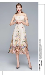 Detailed close-up of colorful floral embroidery on high-waist champagne mesh dress