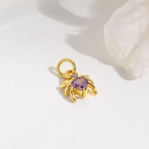 Minimalist gold spider pendant featuring a sparkling purple heart-shaped stone and metal loop