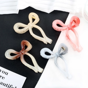 Elegant bow hair claws in gradient colors including cream pink and blue marble finish