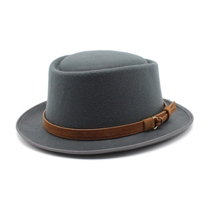 Detail of dark grey wool felt pork pie hat with brown suede band and golden buckle