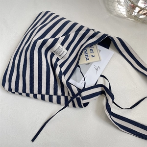 Détail d'un sac cabas en toile rayée montrant la texture du tissu et sa grande capacité