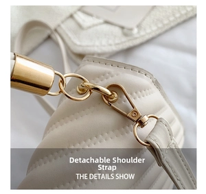 Close-up of detachable strap hook and golden hardware on quilted white shoulder bag