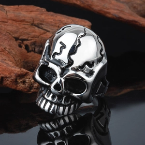 Macro detail of silver stainless steel skull ring with gothic relief and sharp reflections